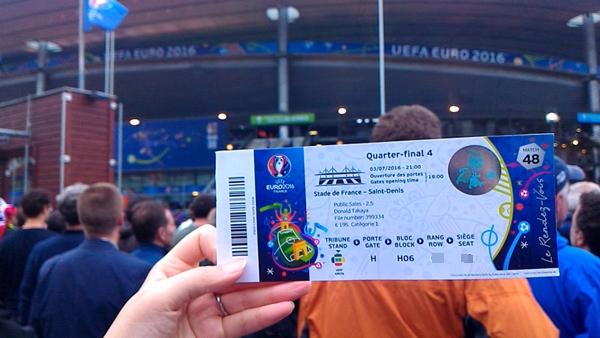 フランスサンドにスタジアムを背景にサッカー欧州選手権EURO2016のチケットをかかげる様子